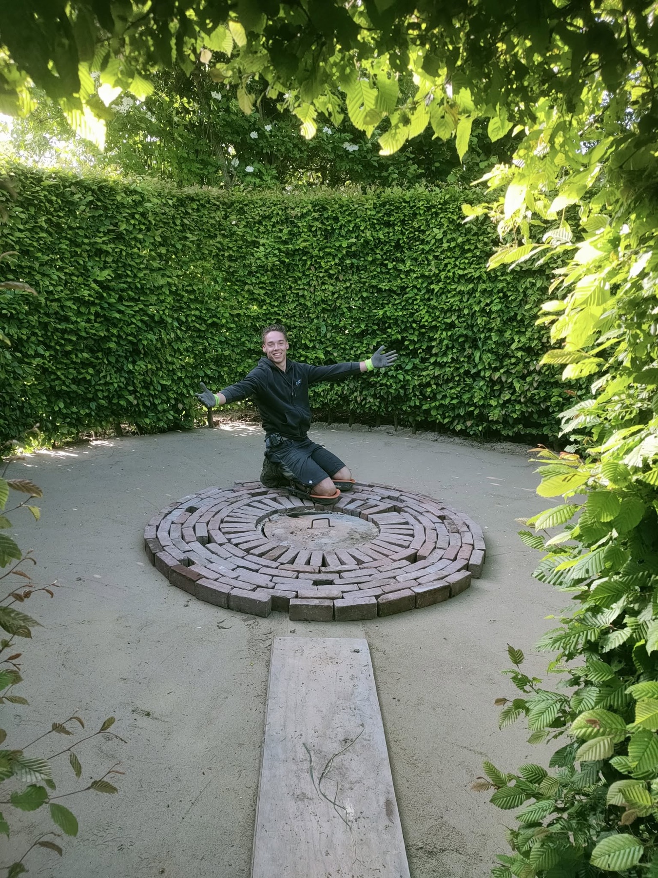 Luuk van Helden aan het werk in een tuin